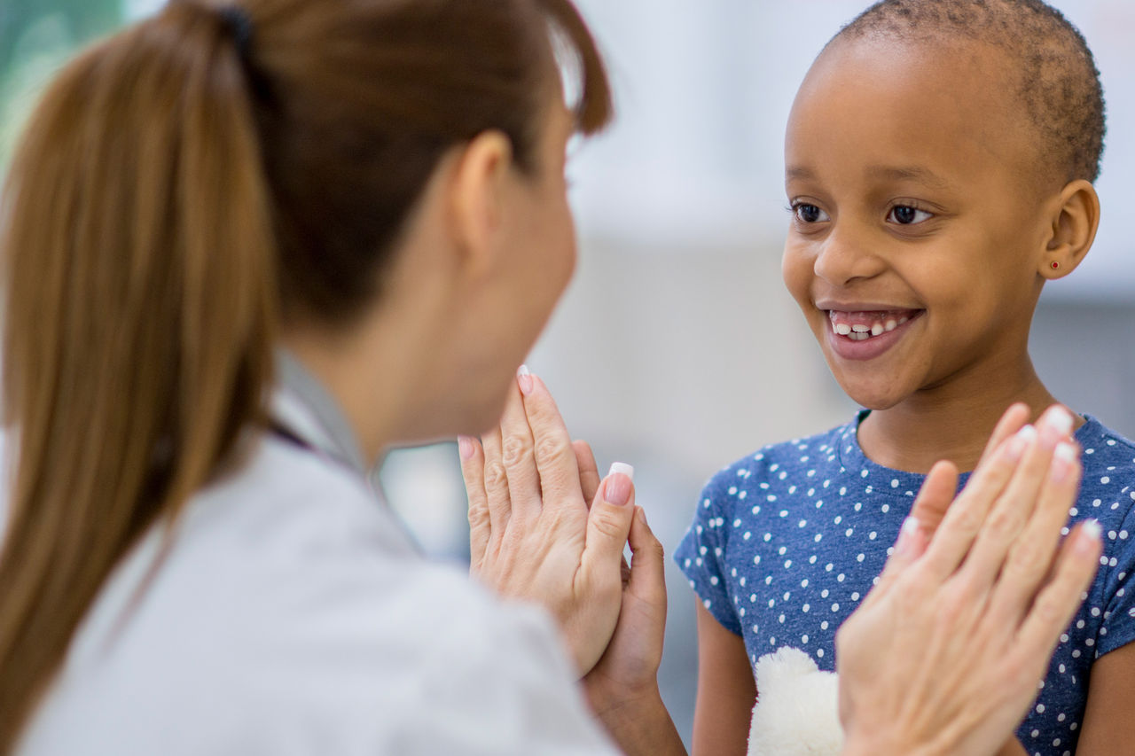 Female doctor giving a double high five to a young female patient