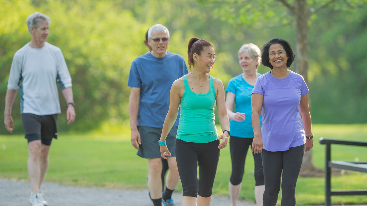 A group of adults walking through a park outside