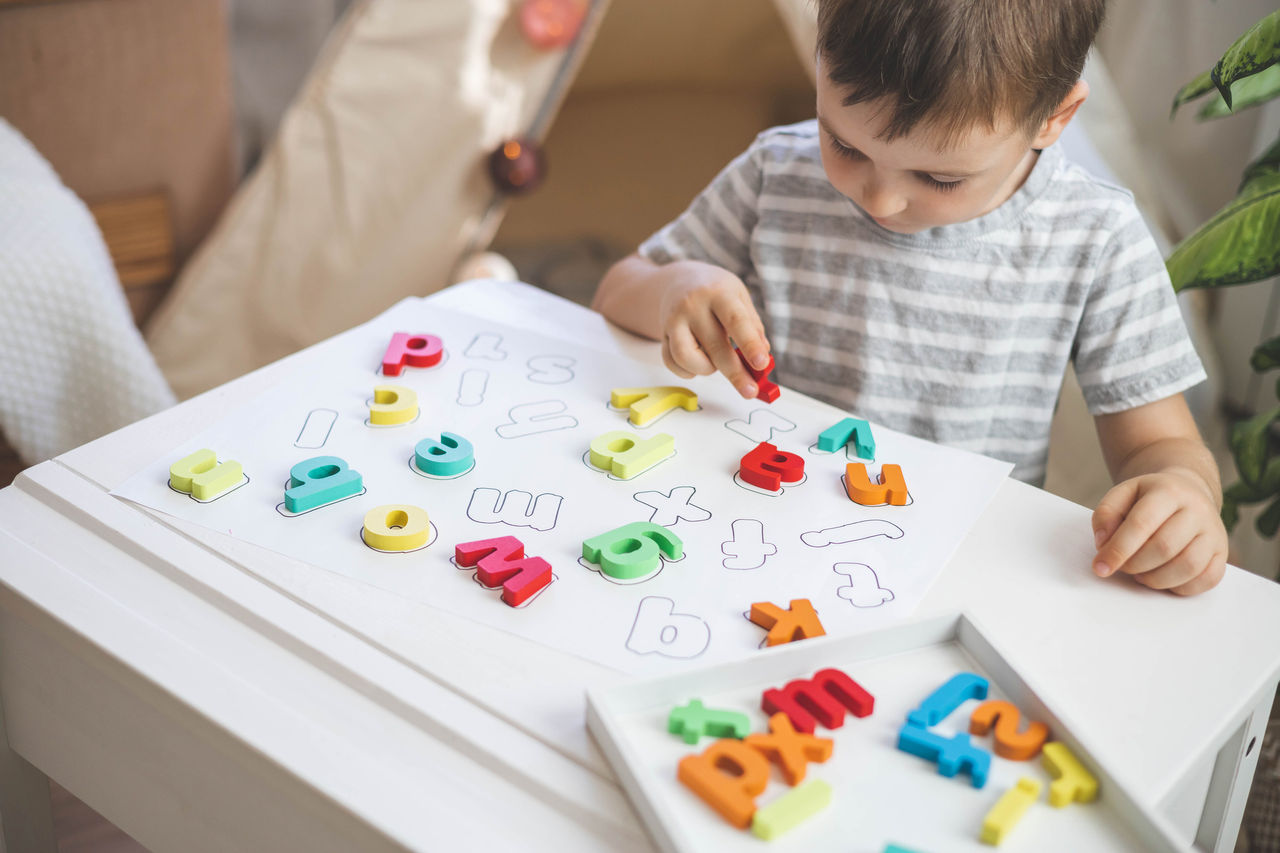 Young child playing with letters.