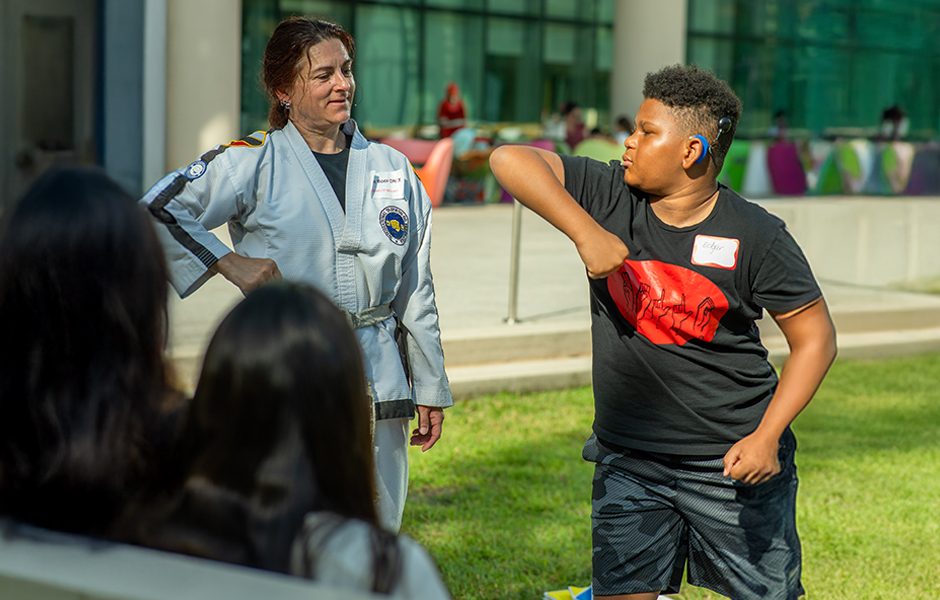 Child at cochlear implant summer camp getting a martial arts lesson