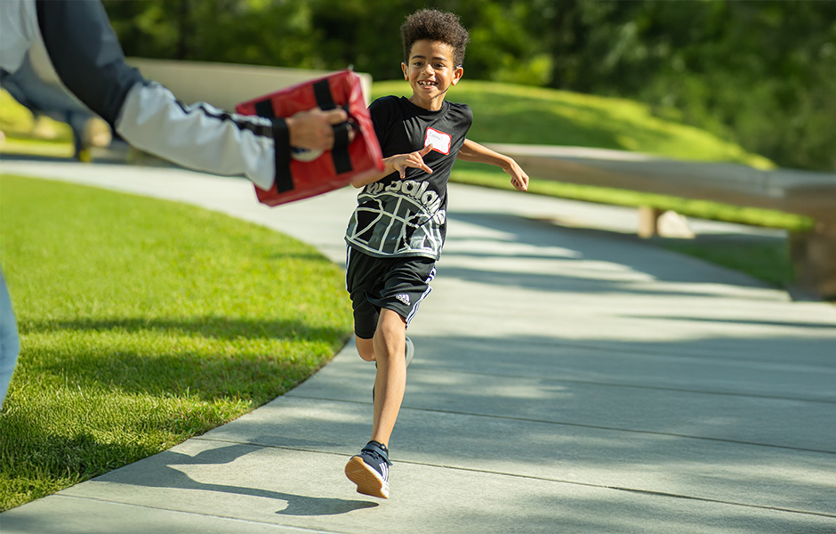 Child at cochlear implant summer camp running