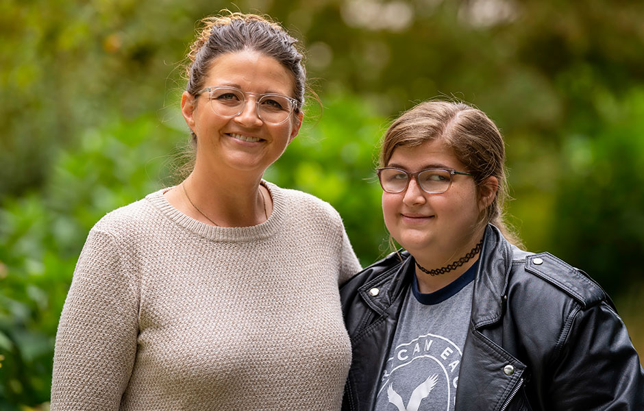 Smiling mom and smiling preschooler look at laptop