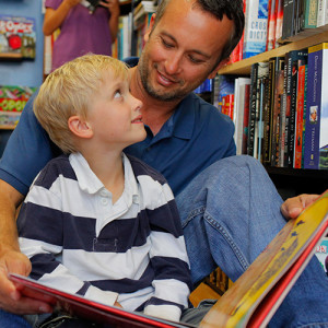 Dad and young son reading in a public library