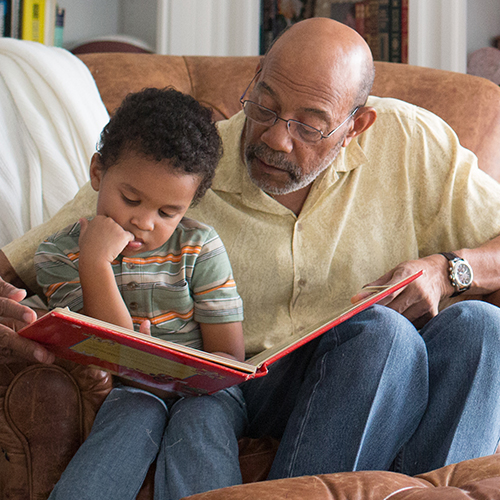 Grandfather reading to young grandson